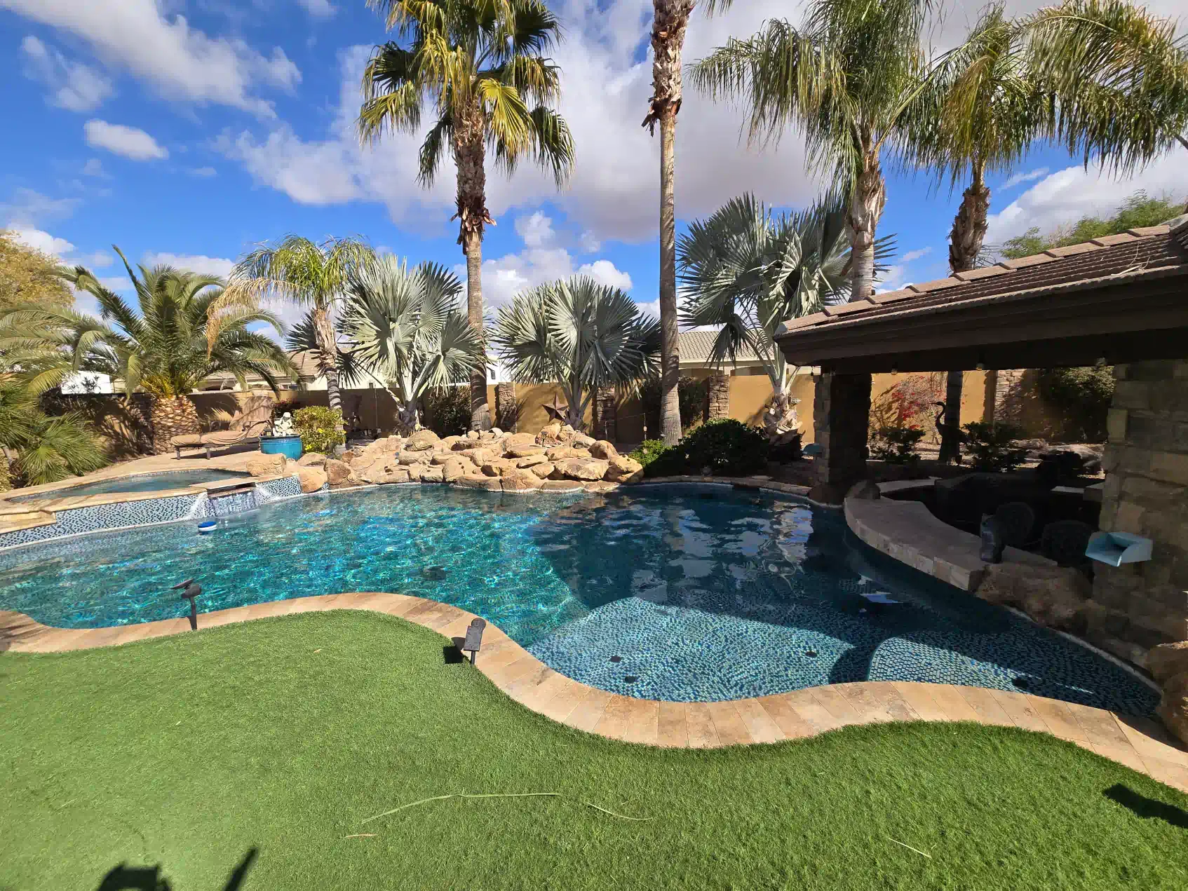 A large swimming pool with palm trees in the background