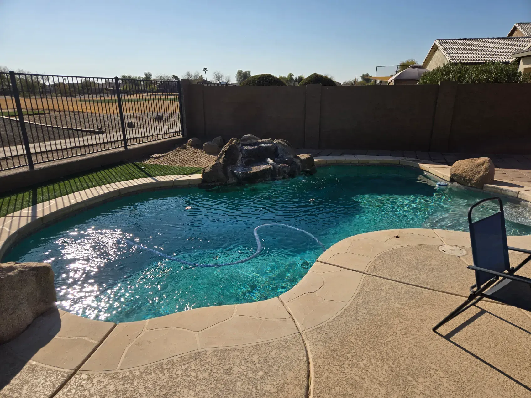 A large swimming pool with a chair in the foreground