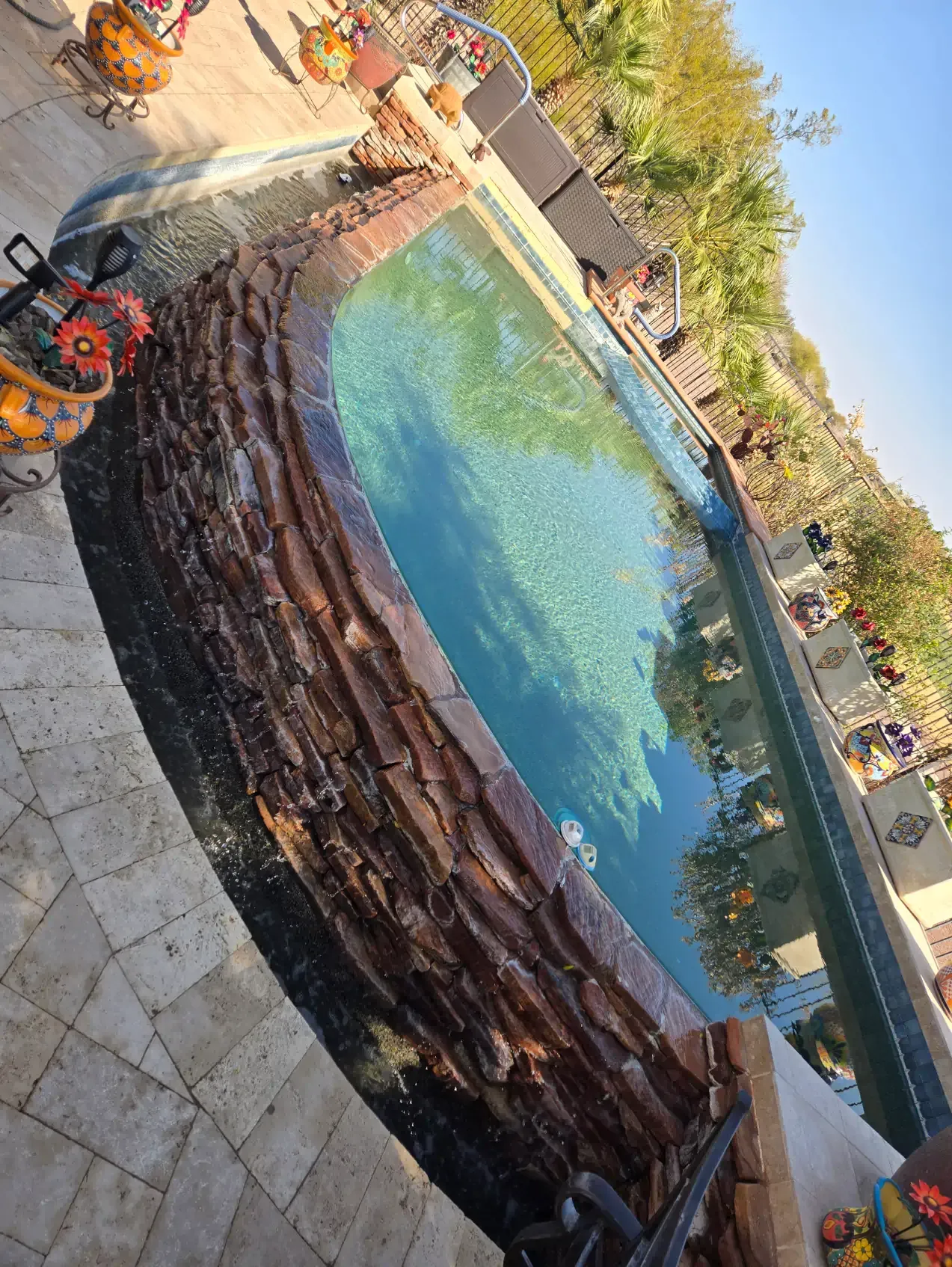A swimming pool with a tree trunk in the middle of it.
