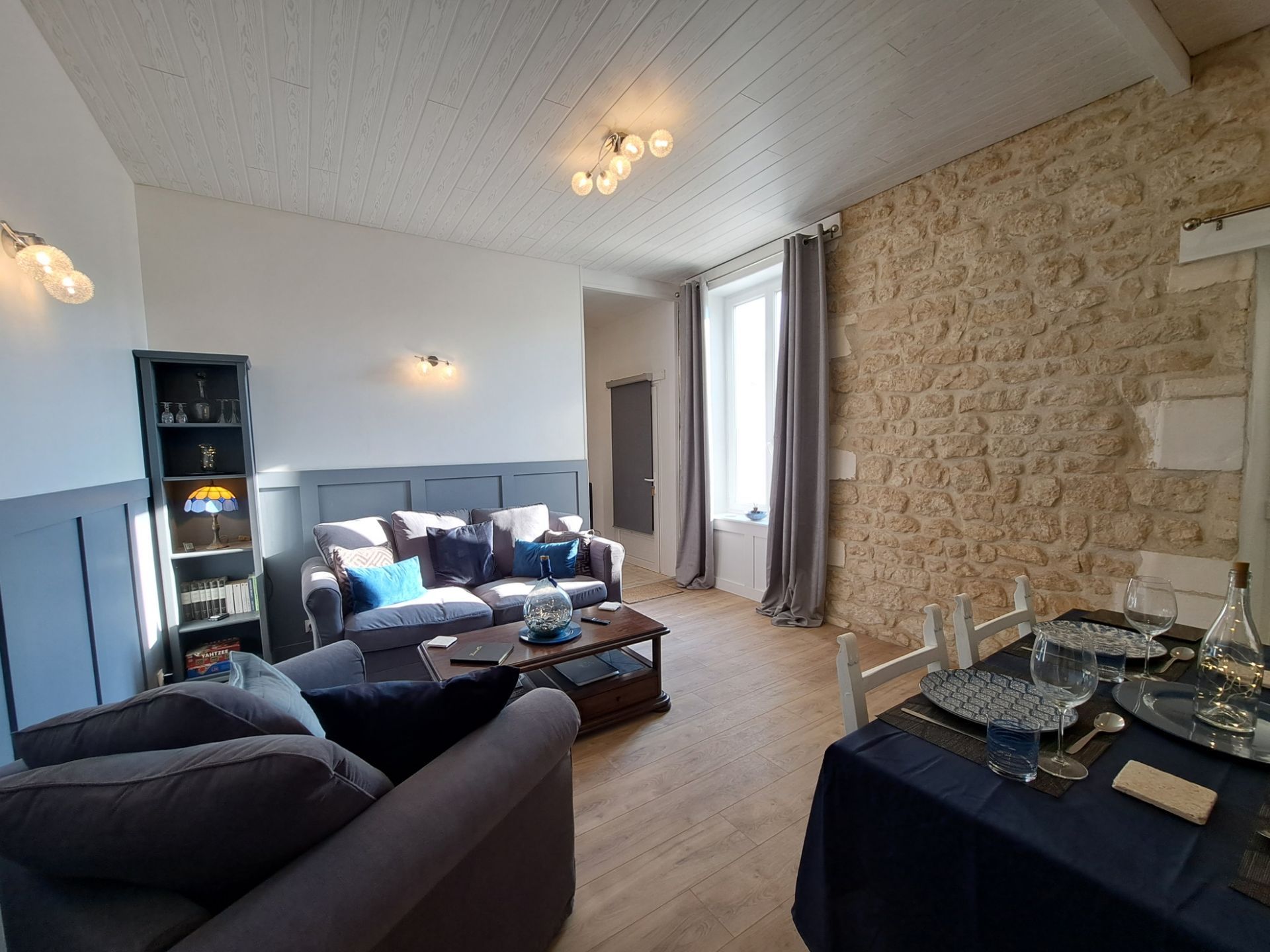 sitting room with grey ikea sofa and exposed stone wall