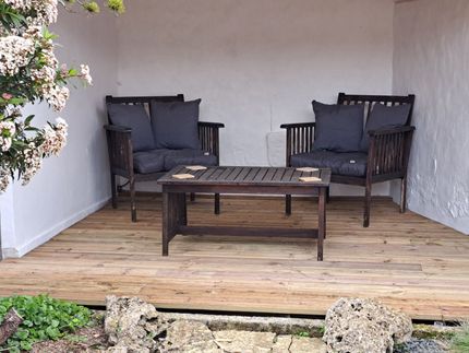 wooden garden furniture with grey cushions on a deck