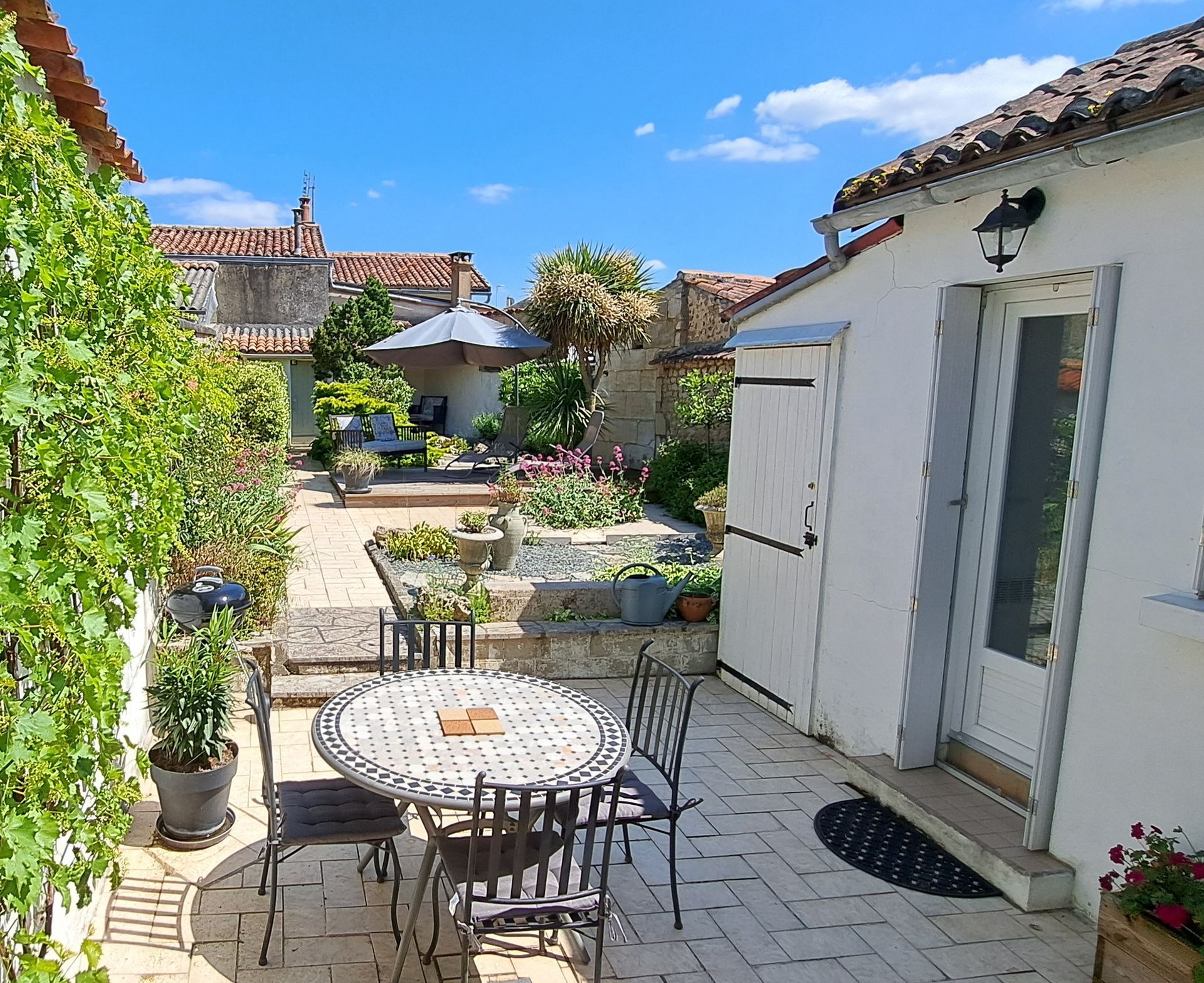view of a white town house from the garden with a palm tree