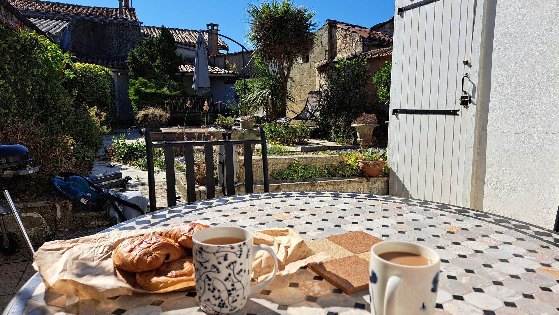 croissants and tea on a coffee table in an enclosed garden