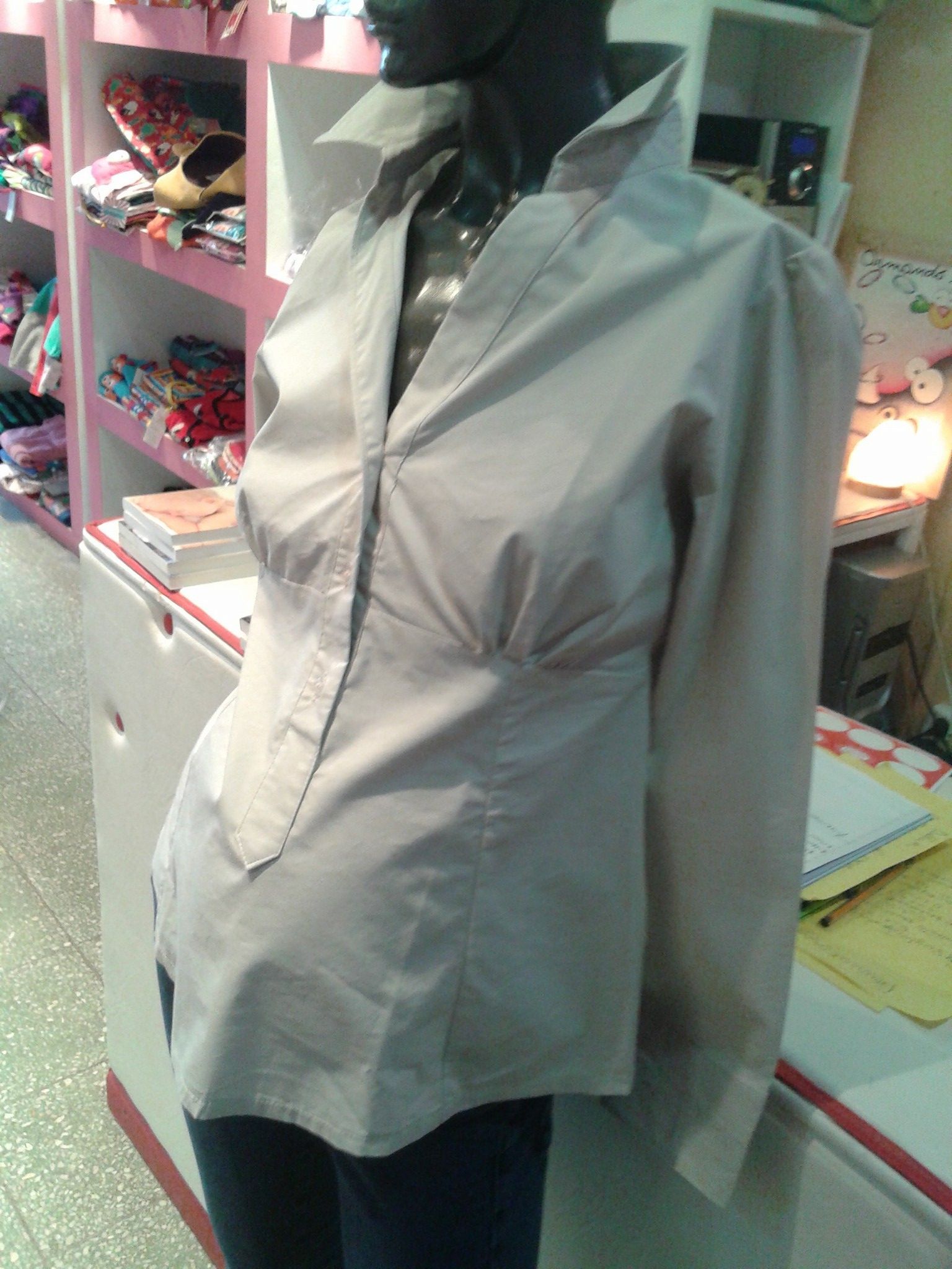 Una camisa blanca está en un maniquí en una tienda.