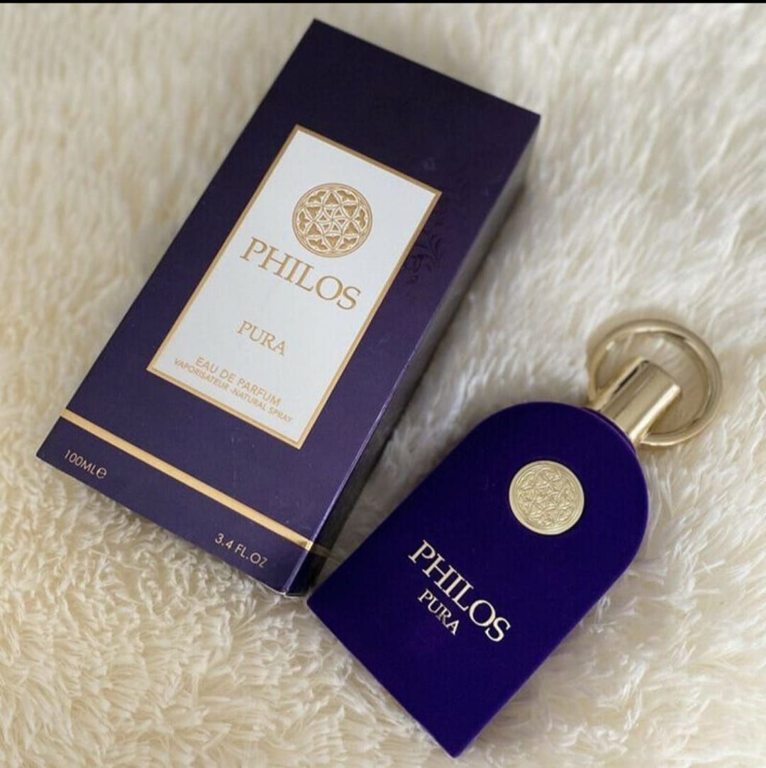 Frasco y caja de perfume Philos Pura de color morado sobre una superficie blanca y esponjosa.