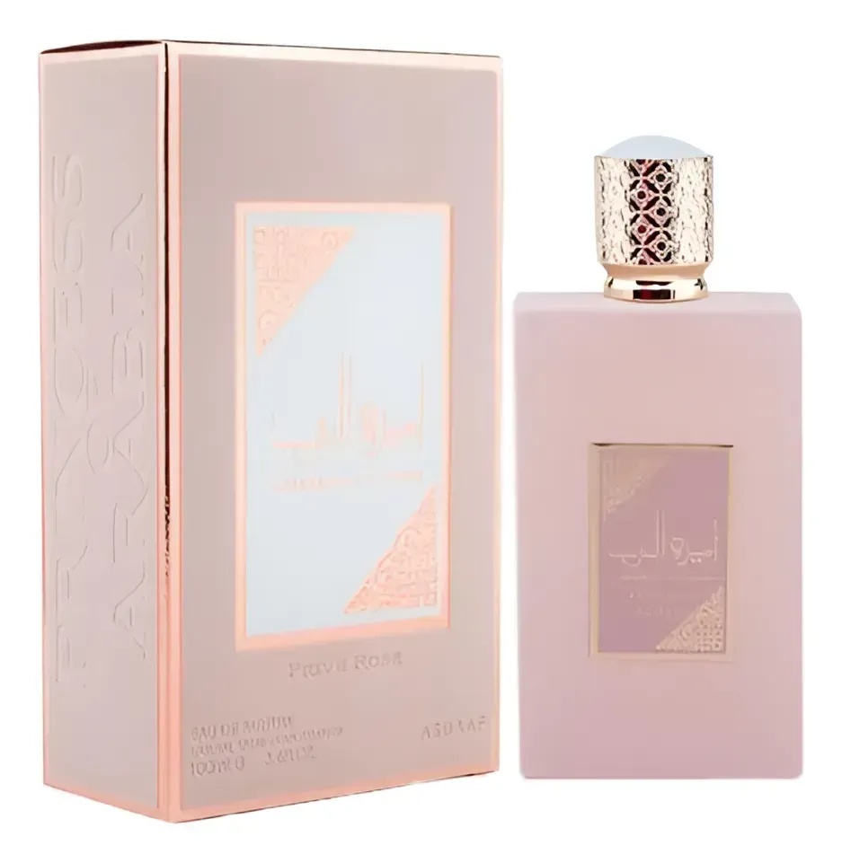 Frasco de perfume rosa y caja. Detalles dorados. Etiqueta blanca y dorada en el frasco y la caja.