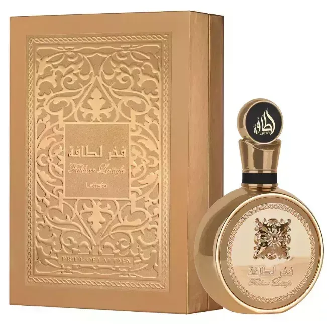 Frasco de perfume y caja de oro con escritura árabe y diseño ornamentado.