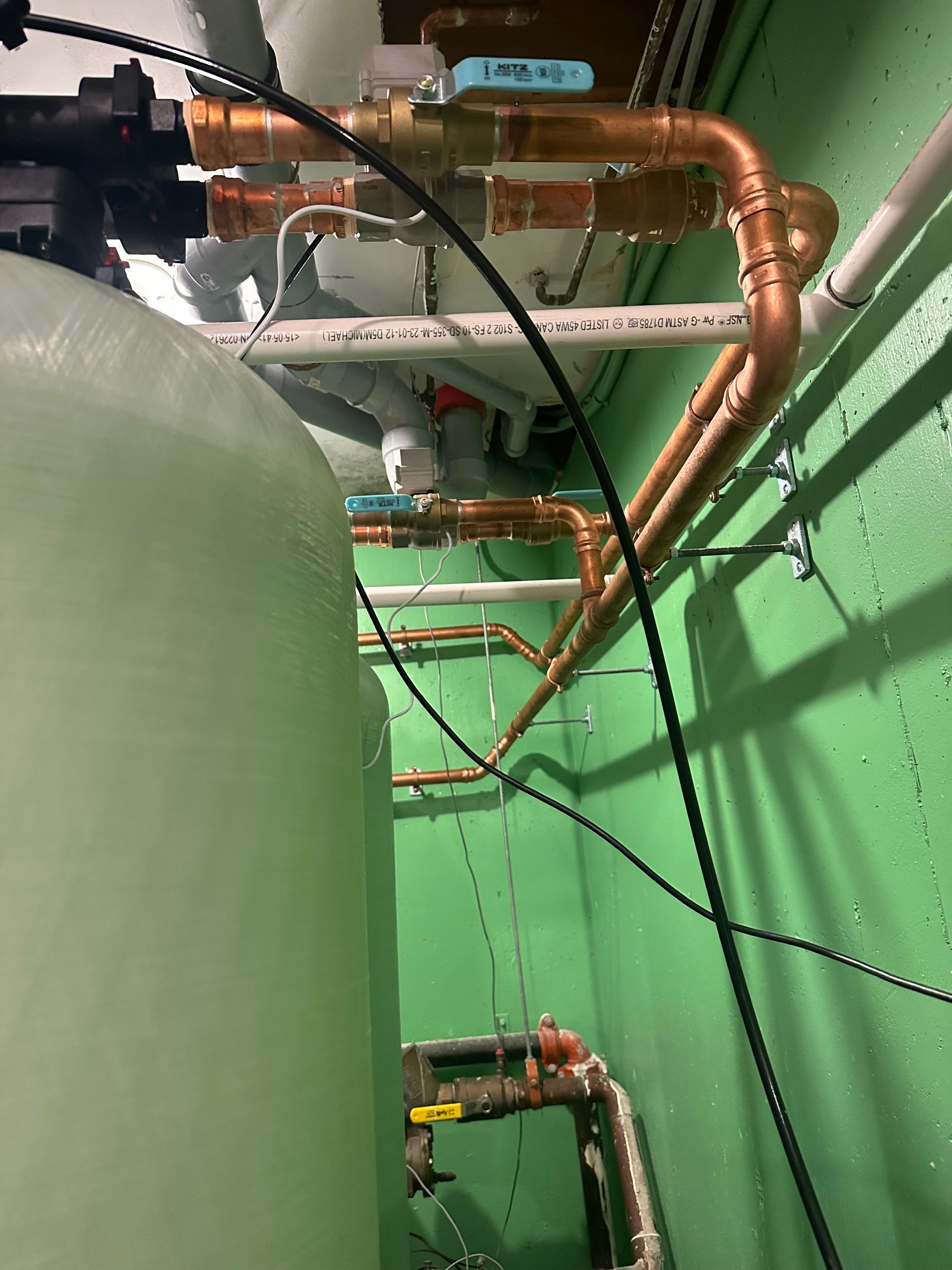 A room with a lot of pipes and wires hanging from the ceiling.