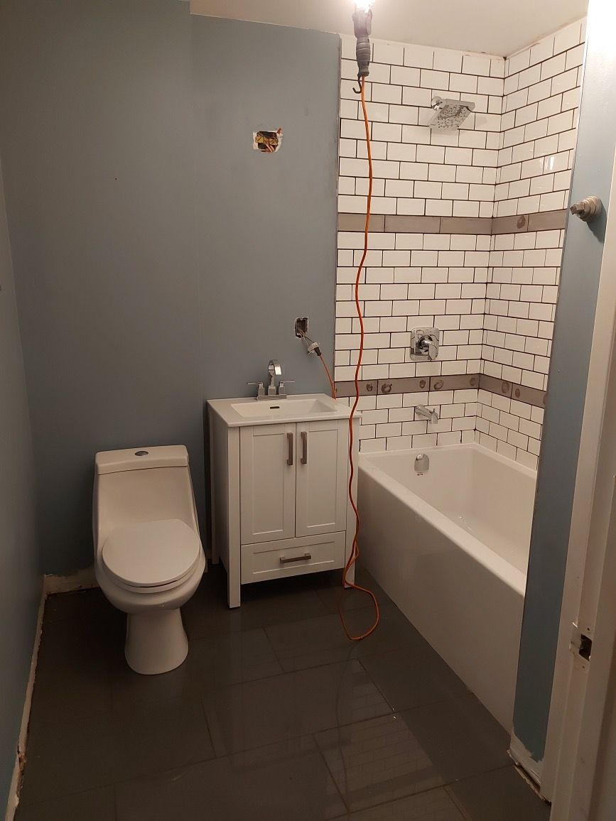 A bathroom with a toilet , sink , and bathtub.