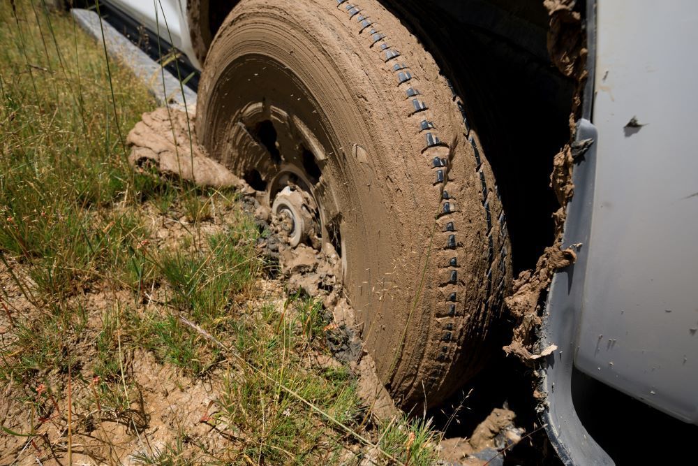 A Car Wheel is Stuck in the Mud on a Muddy Road — Perlyn Towing in Rockhampton City, QLD