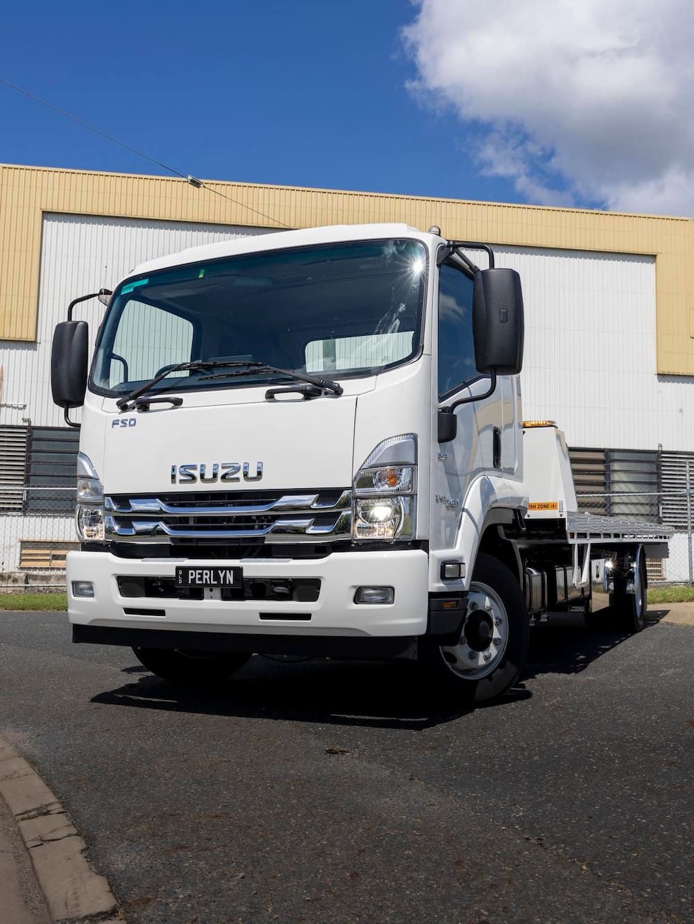 A White Isuzu Truck is Parked in Front of a Building — Perlyn Towing  in Rockhampton City, QLD