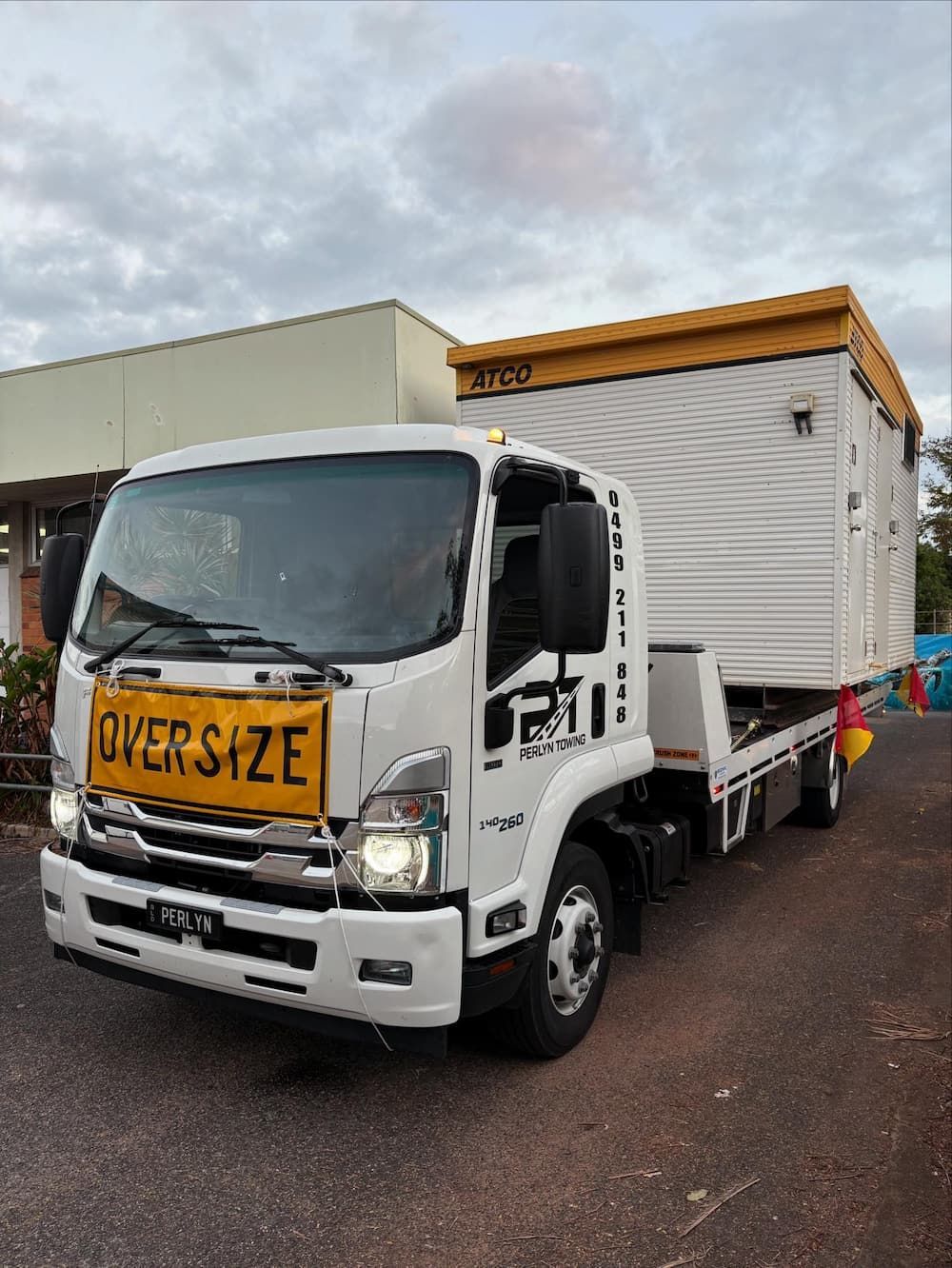 A white truck with a yellow sign on the front that says  oversized — Perlyn Towing  in Rockhampton City, QLD