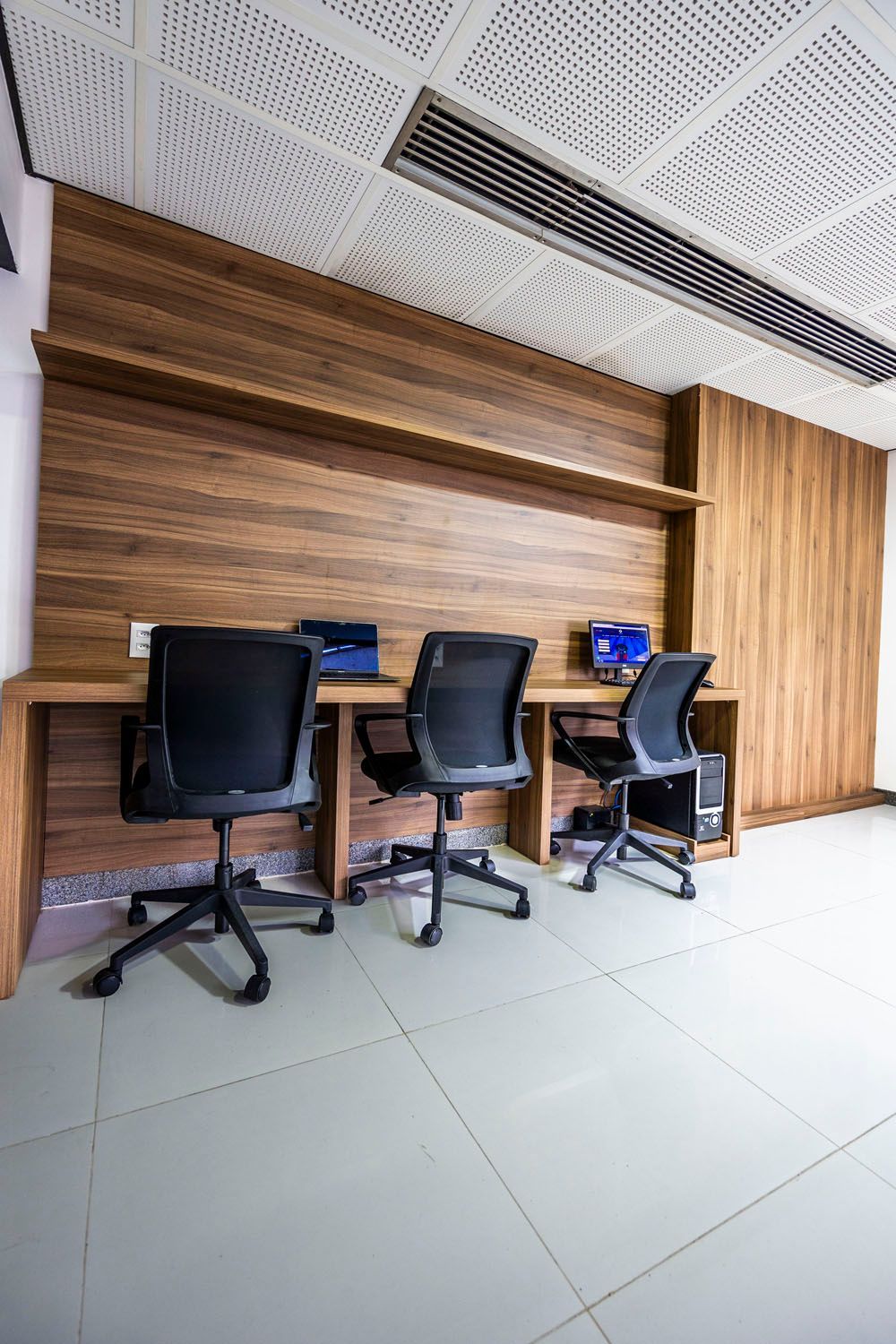 Uma sala com três mesas e cadeiras.