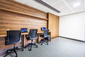 Uma fileira de mesas e cadeiras em um escritório com uma parede de madeira.