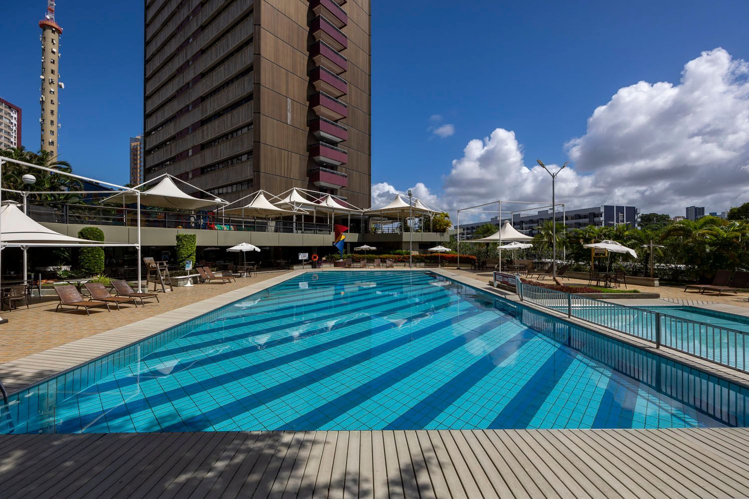 Uma grande piscina em frente a um prédio alto.