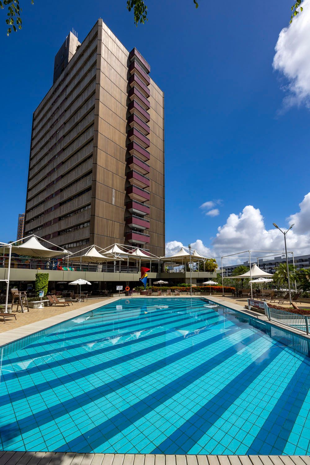 Uma grande piscina em frente a um prédio alto.