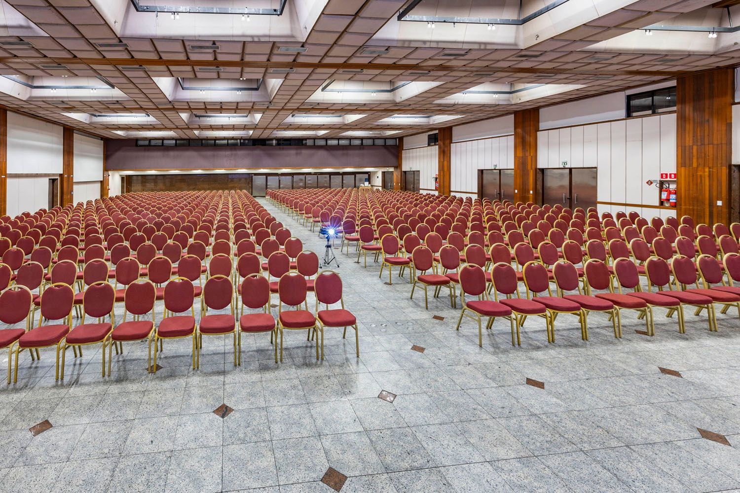 Uma sala grande com fileiras de cadeiras vermelhas