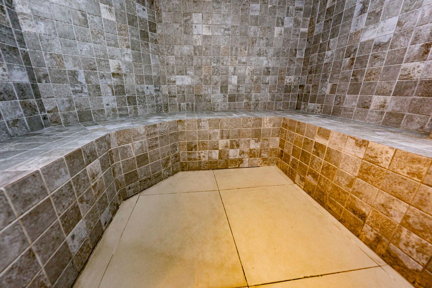 Uma sala com uma parede de tijolos e piso de ladrilho.