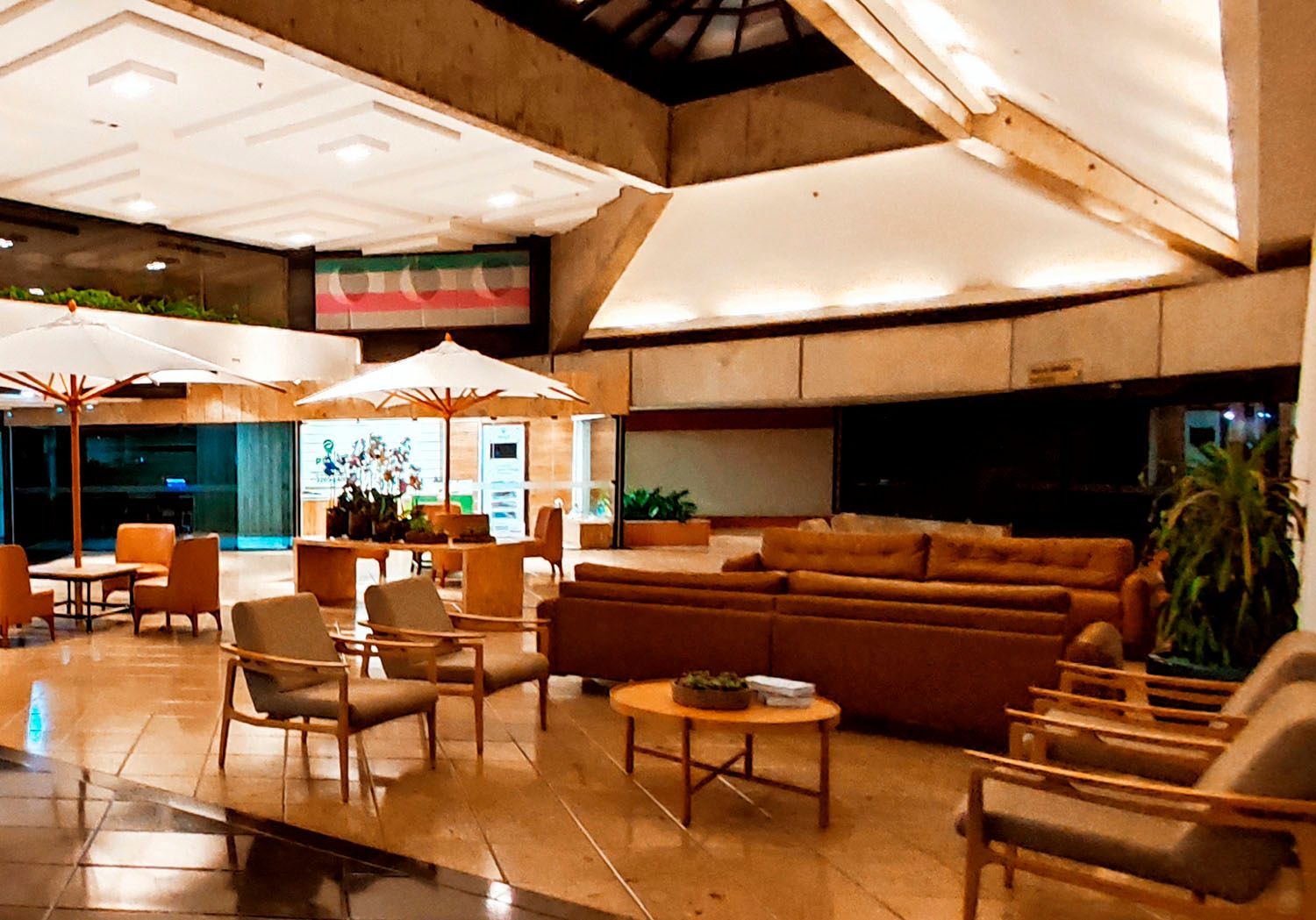 Um lobby de hotel com muitos móveis e guarda-sóis