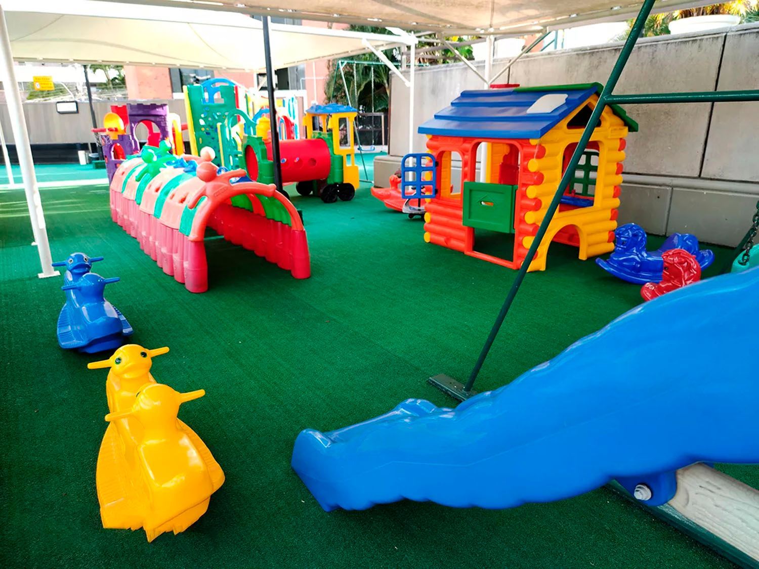 Um parque infantil com escorregador e uma casa