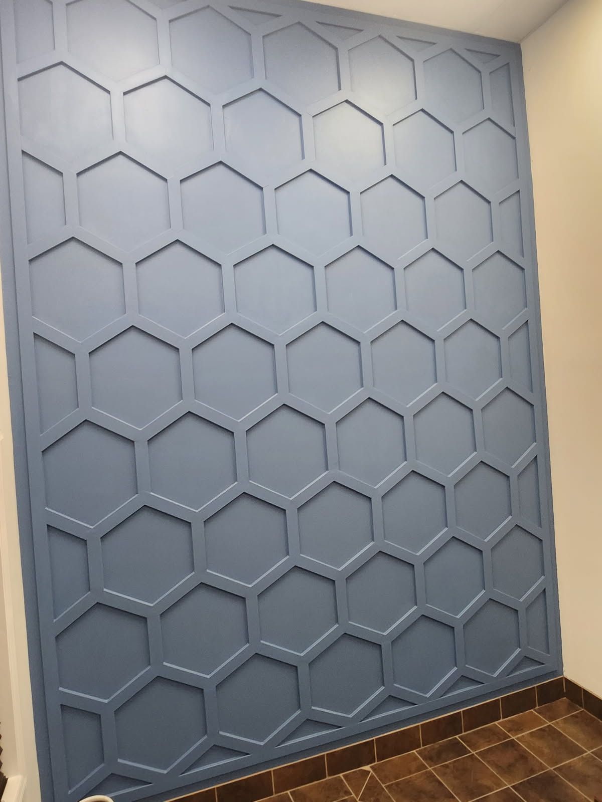 Dark stained corner bookshelf filled with books, set against red walls and a gray carpet.