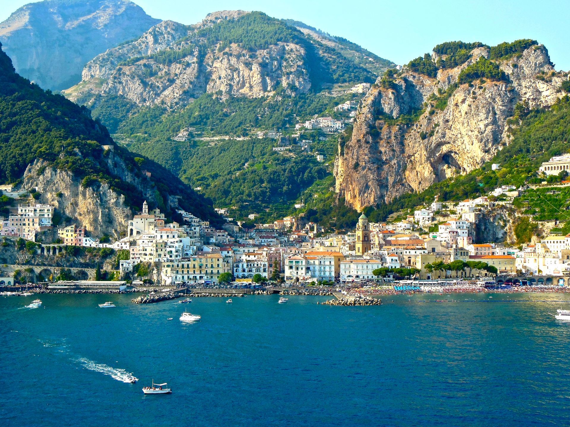 A city in the middle of a body of water with mountains in the background
