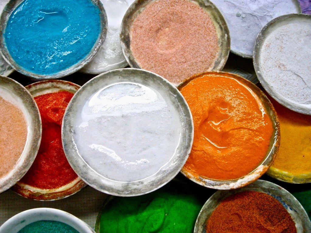 A bunch of bowls filled with different colored liquids