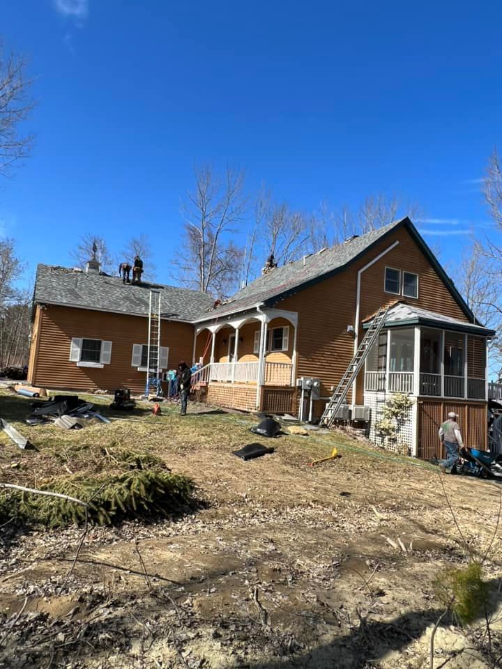A large house with a porch and a roof is being remodeled.
