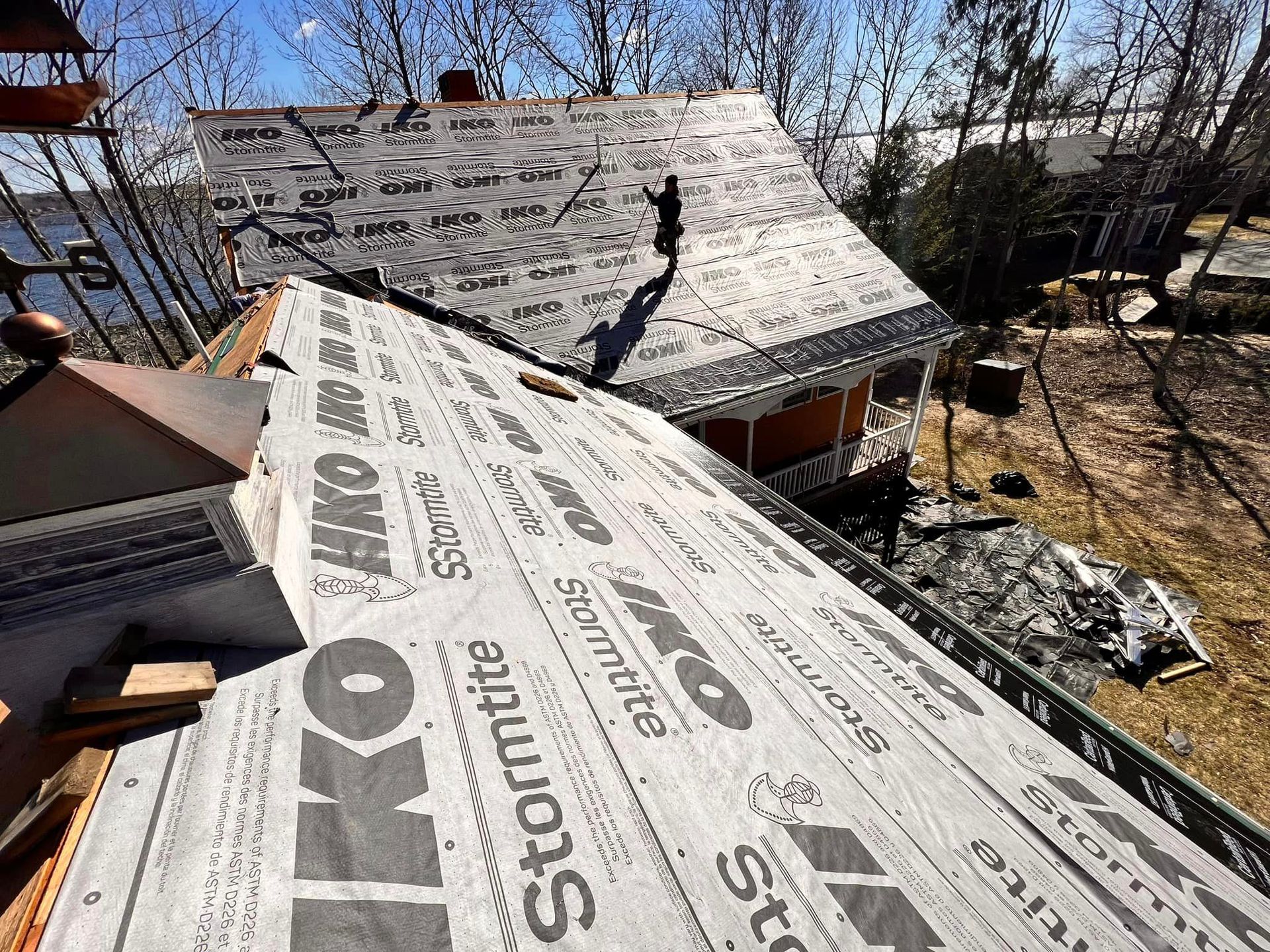 The roof of a house is being covered with a roofing material.