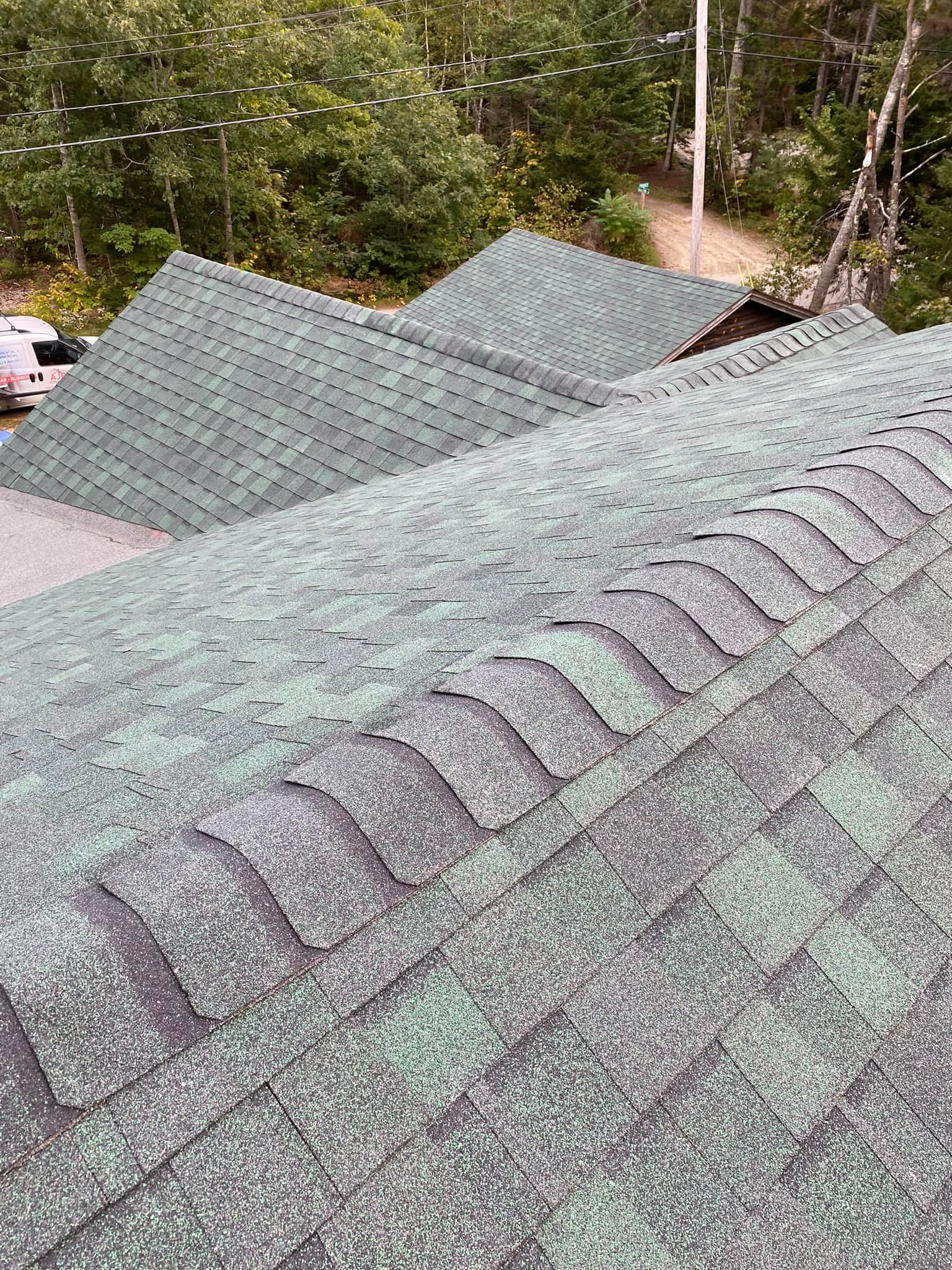 A roof with a lot of green shingles on it.