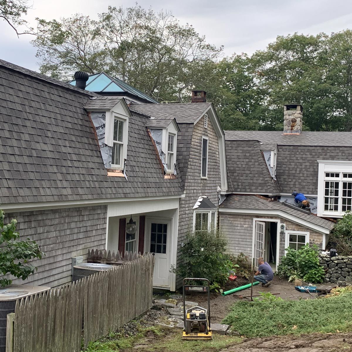 A man is working on the roof of a house
