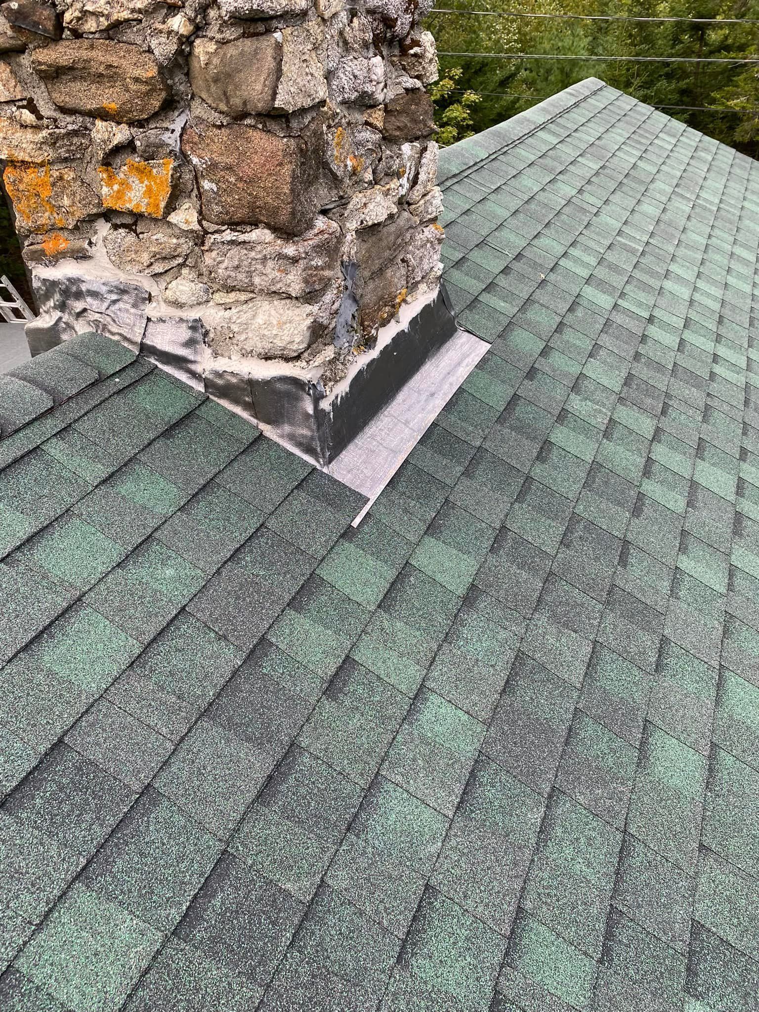 A green roof with a chimney on top of it.