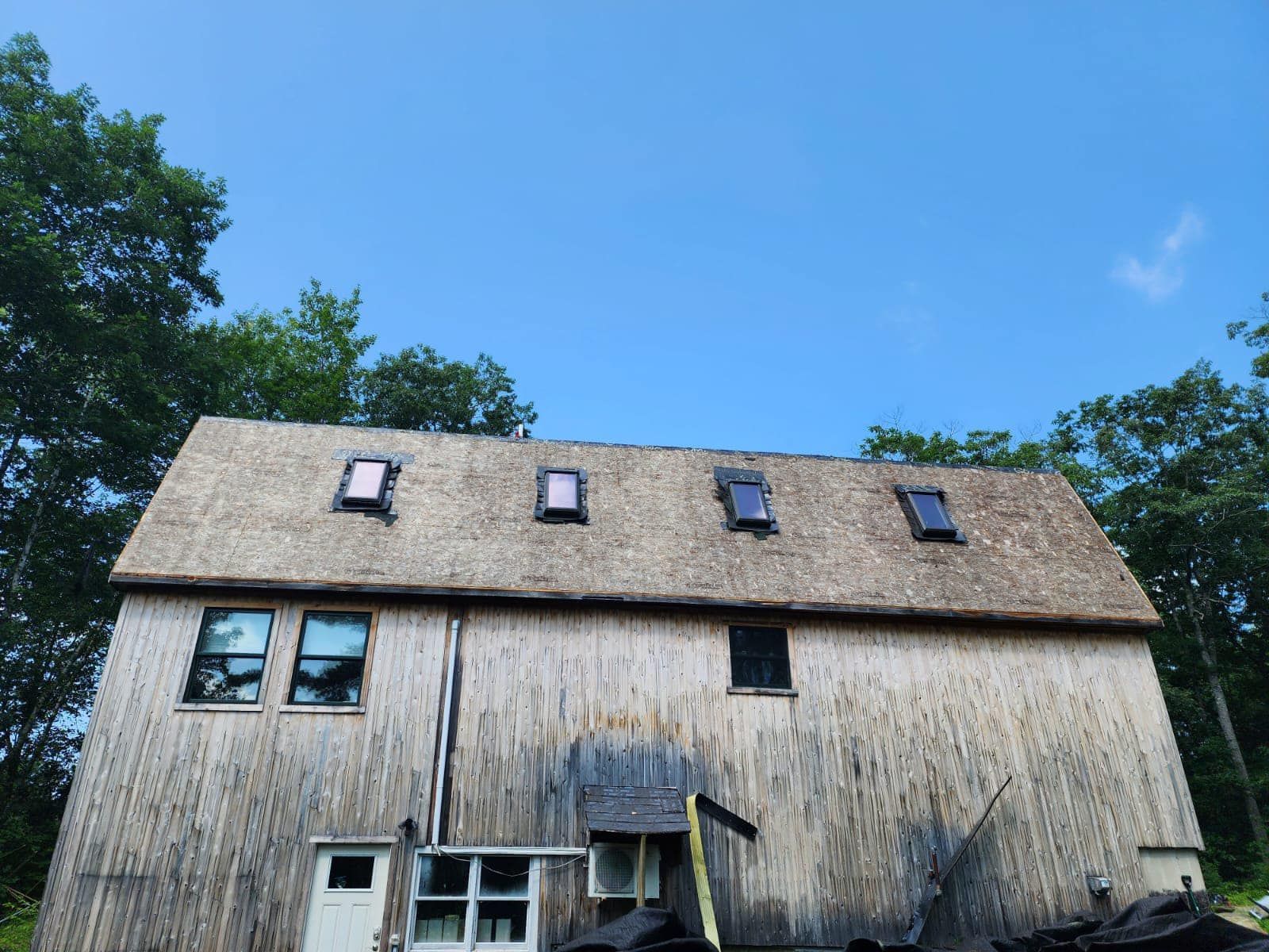 A wooden barn with a skylight on the roof