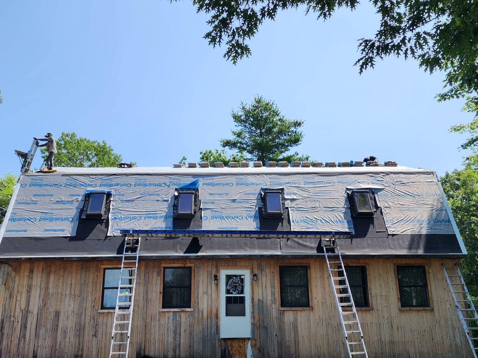 A man is working on the roof of a house