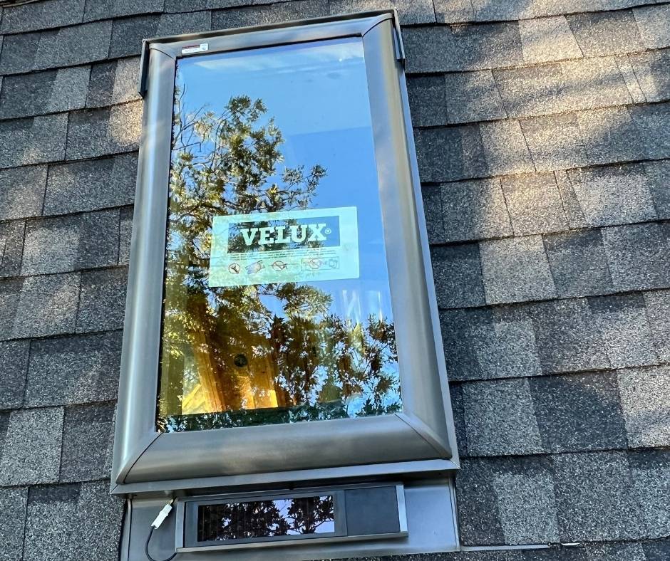 A velux skylight is sitting on top of a roof