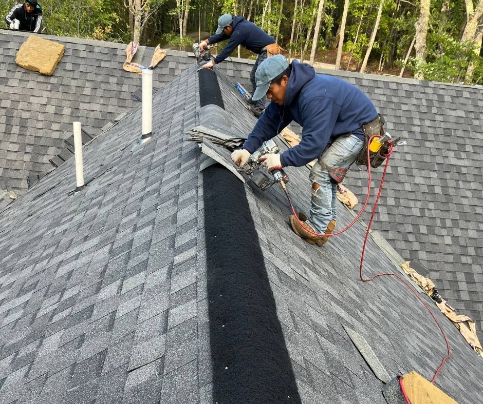 Two men are working on the roof of a house.