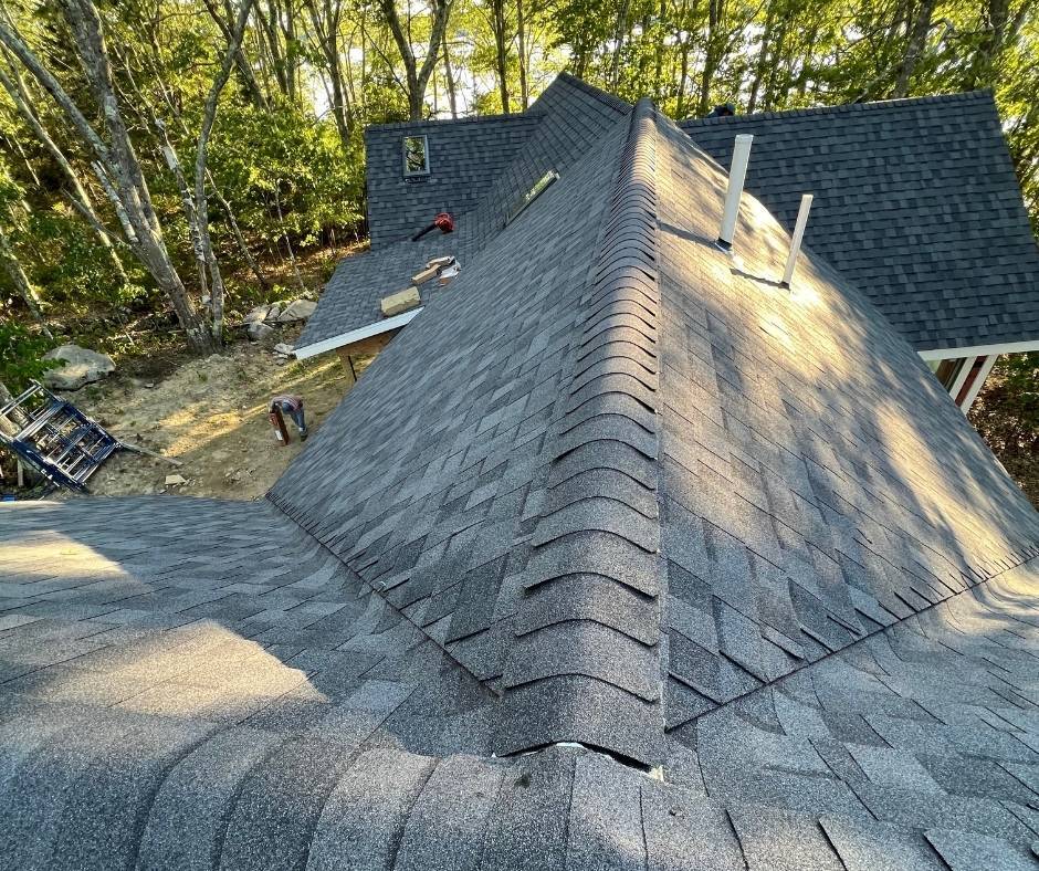 A roof is being installed on a house in the woods.