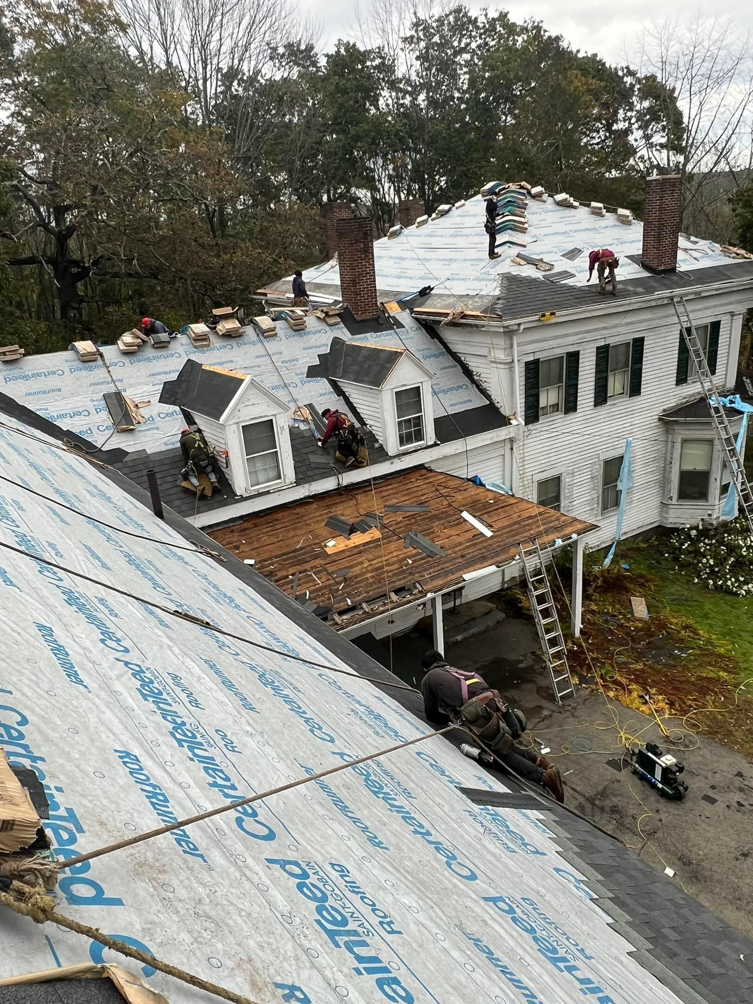 An aerial view of a house with a roof being repaired.