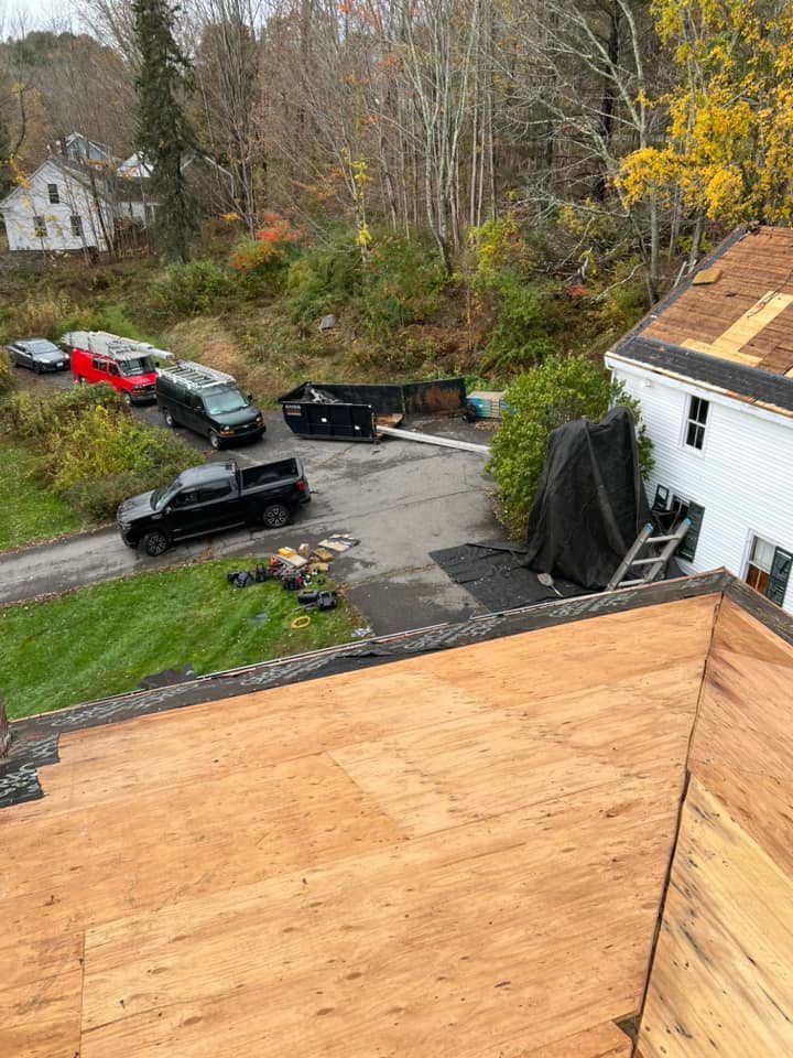 An aerial view of a house with a wooden roof being installed.