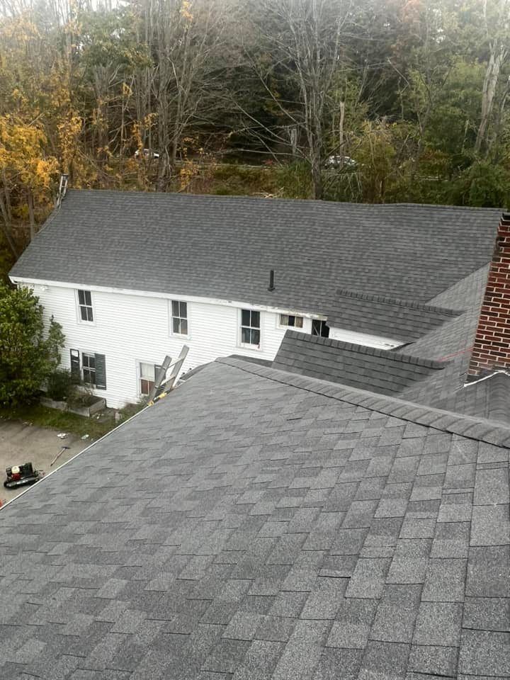 An aerial view of a house with a gray roof and a chimney.