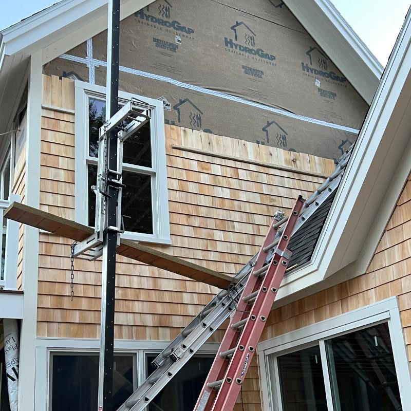A ladder is sitting in front of a house under construction.