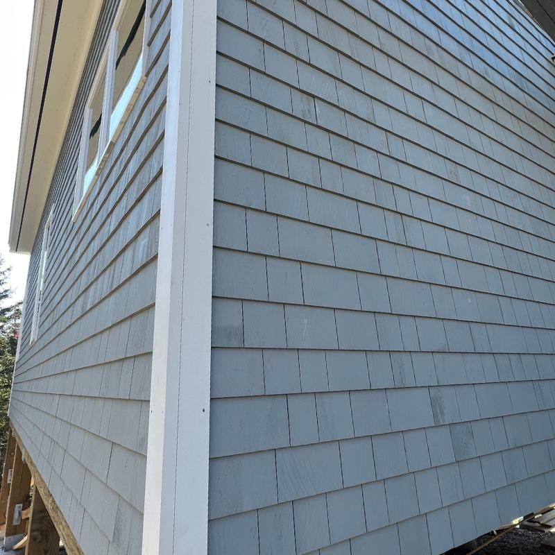 A house with a gray siding and white trim