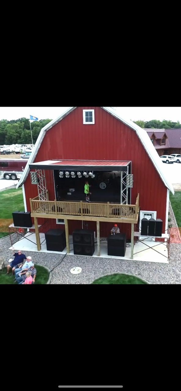 An aerial view of a stage in front of a red barn.