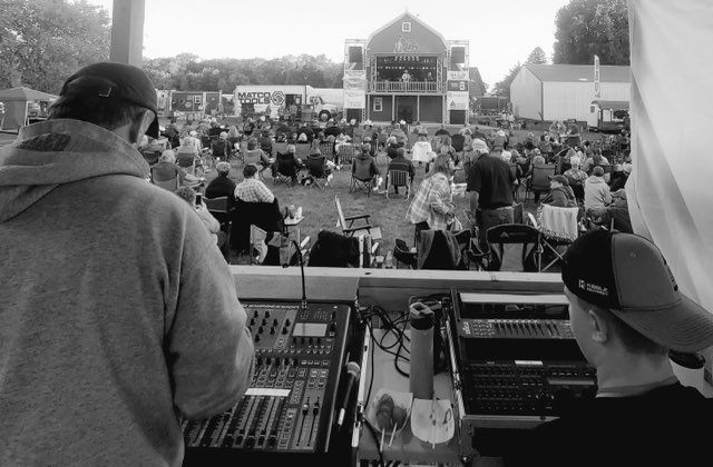 A black and white photo of a man behind a mixer