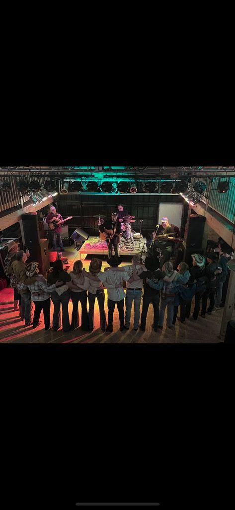 A group of people are standing in a circle on a stage.