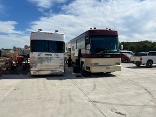 Two rvs are parked next to each other in a parking lot.