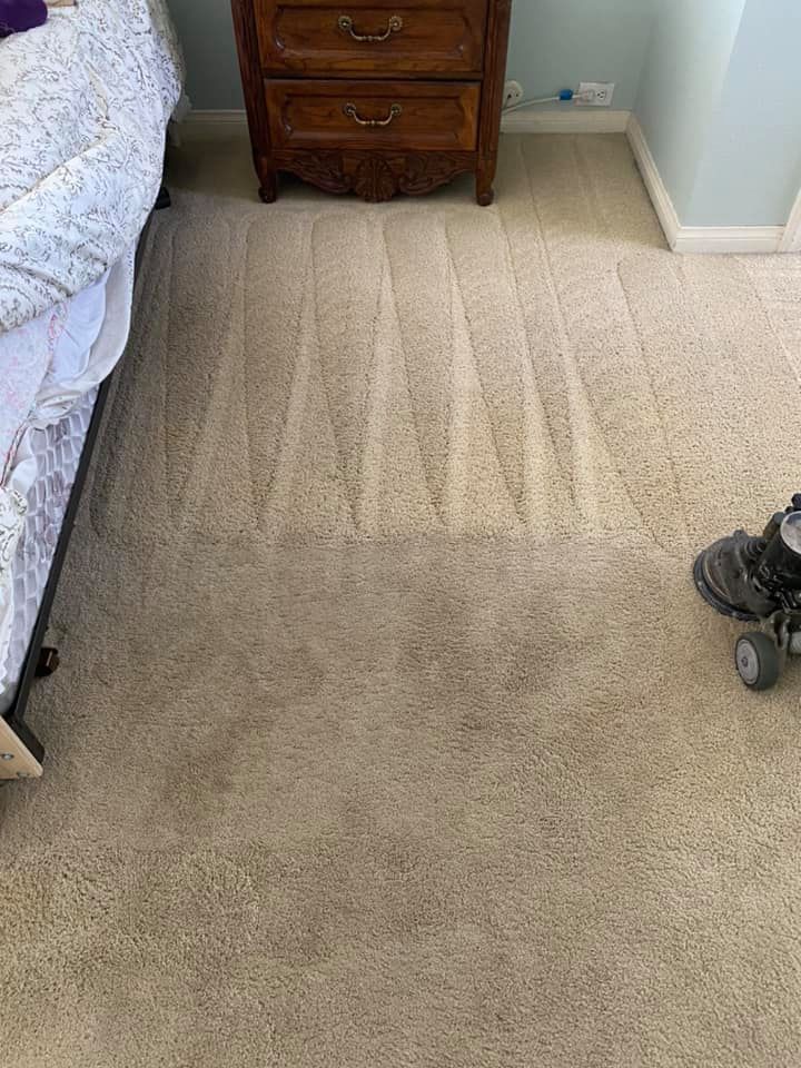 A vacuum cleaner is sitting on the floor next to a bed in a bedroom.