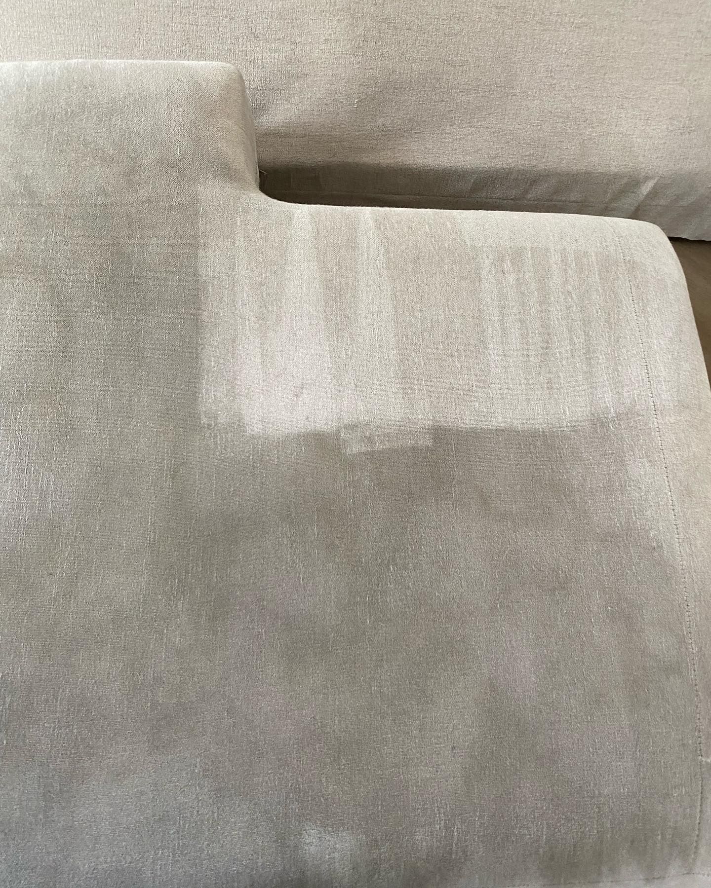 A close up of a couch with a stain on it.