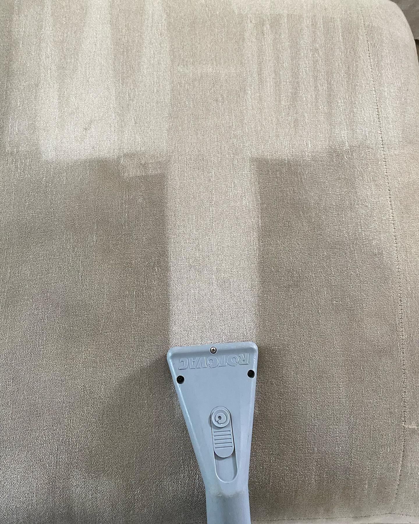 A close up of a carpet being cleaned with a vacuum cleaner.