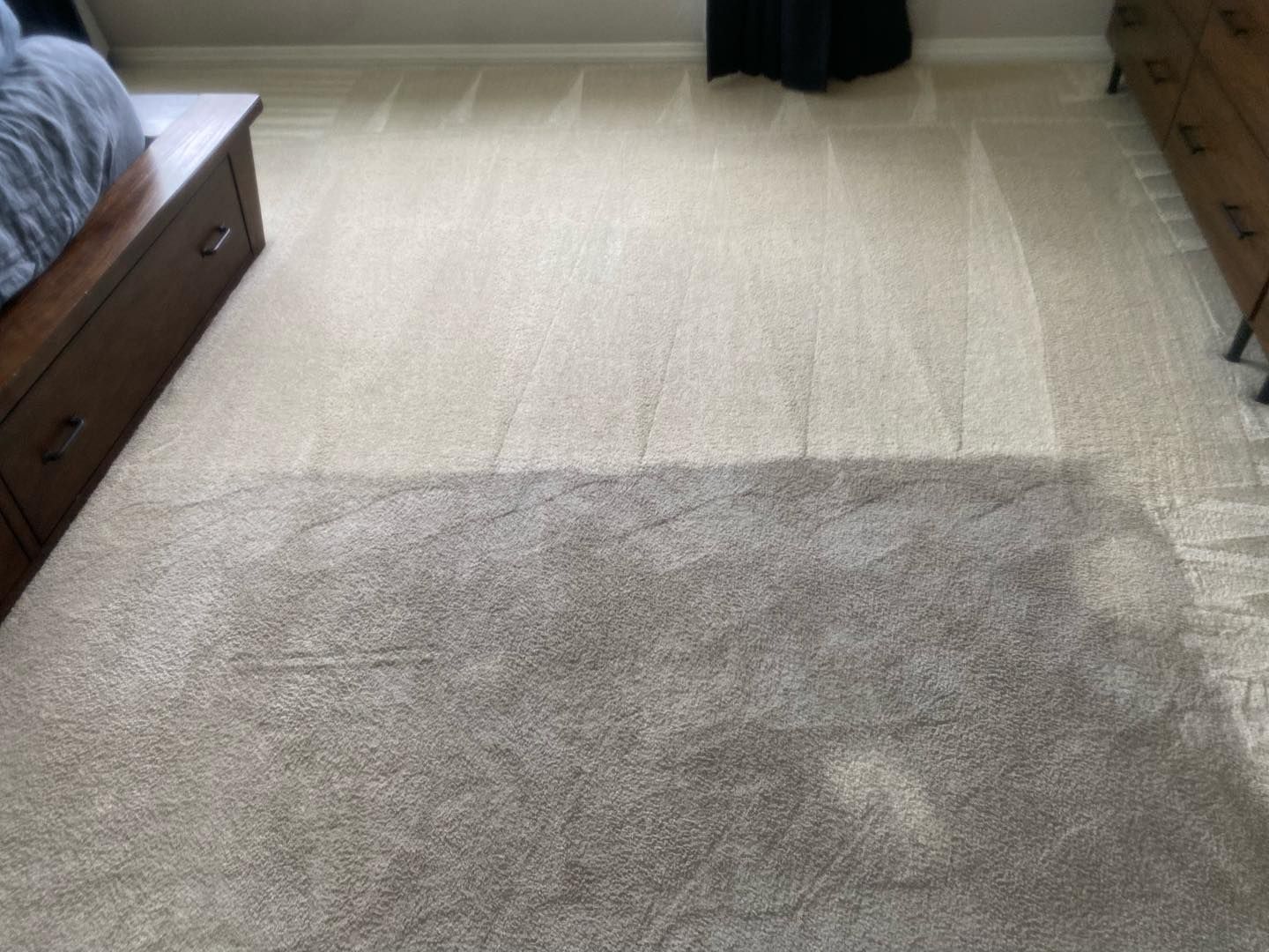 A bedroom with a bed and a rug on the floor.